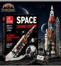 JIE STAR Space Launch System building block set shown with its retail box on the left and the assembled model rocket on the right, set against a space-themed background with planets and a moon.