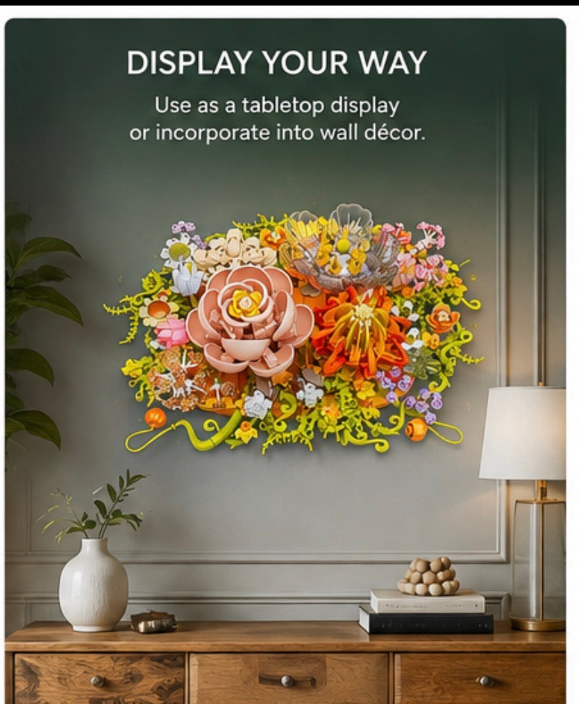 A colorful 3D floral wall art piece mounted on a gray wall above a wooden console table with a lamp and vase. Text at the top reads, 'DISPLAY YOUR WAY Use as a tabletop display or incorporate into wall décor.